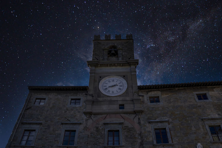 Low angle view of clock tower against sky at night