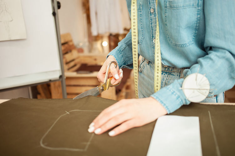 Seamstress cut out from fabric details of future clothes, pattern. fashionable sewing 