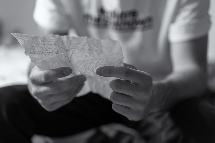 Midsection of man holding paper