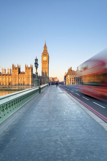 Double-decker bus passes on westminster bridge, in front of westminster palace and clock tower of big ben (elizabeth tower), london, england, united kingdom
