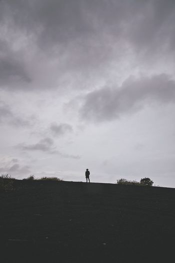 Silhouette man standing on landscape against sky