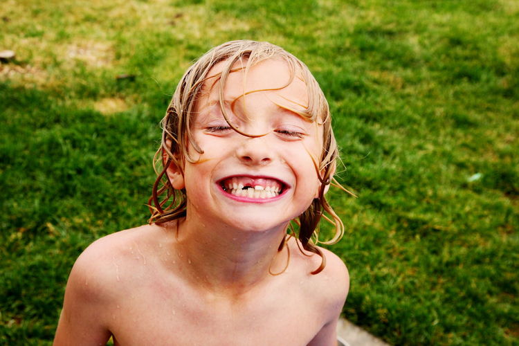 Portrait of shirtless boy showing gap toothed