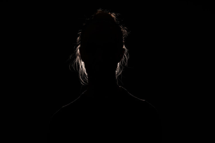 Portrait of silhouette woman against black background