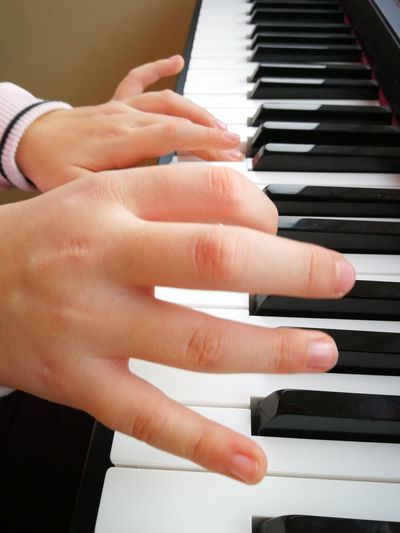 Cropped image of hands playing piano