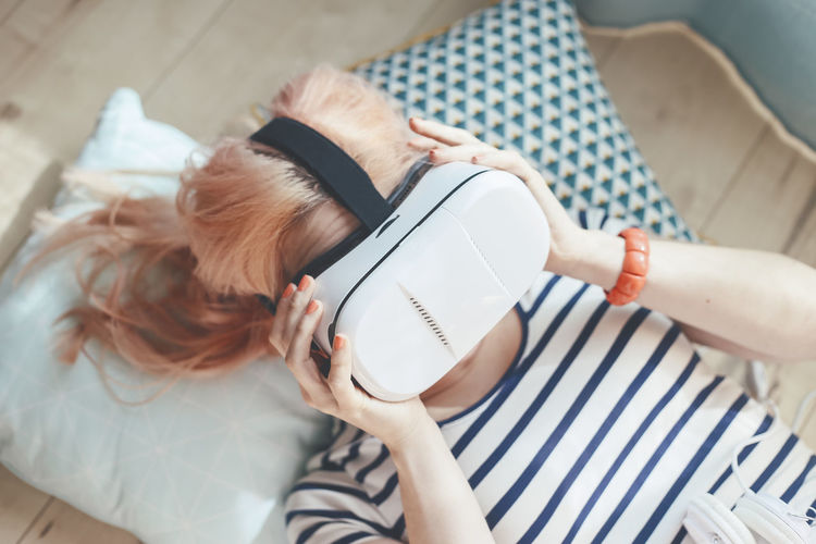 Young woman putting on virtual reality glasses