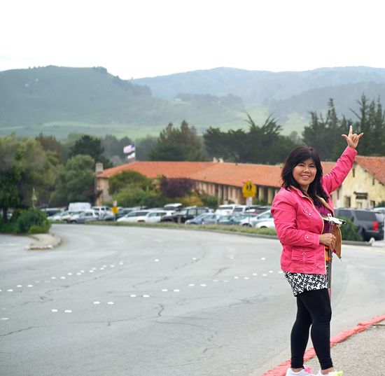 Full length of woman standing on road against mountain
