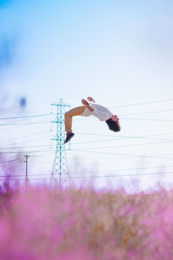 Woman juping against clear sky