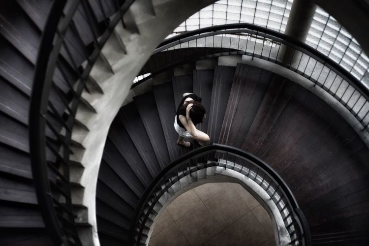 High angle view of woman walking on spiral staircase