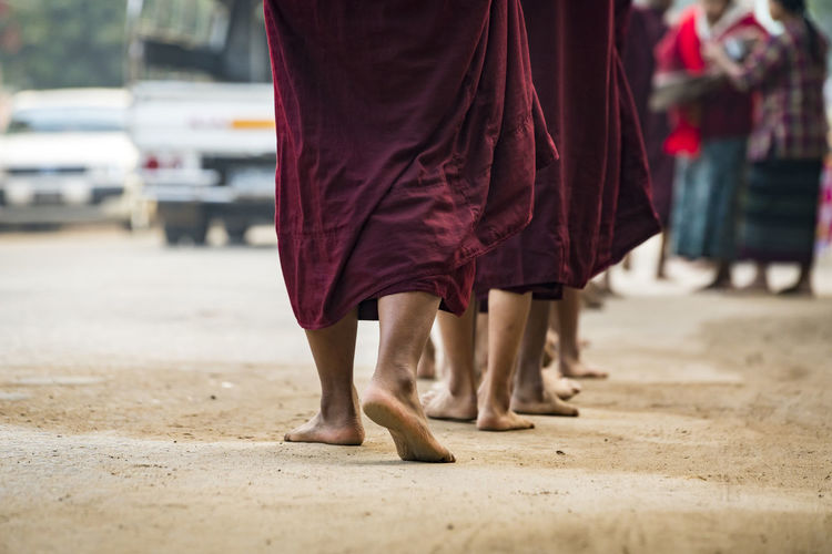 Detail shot of feet of monks waiting in queue while receiving alms, nyaung u, myanmar