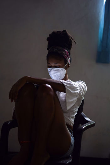 Young woman in face mask using smartphone