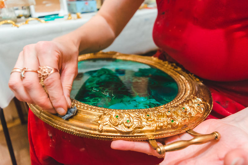 Midsection of woman decorating ornate container
