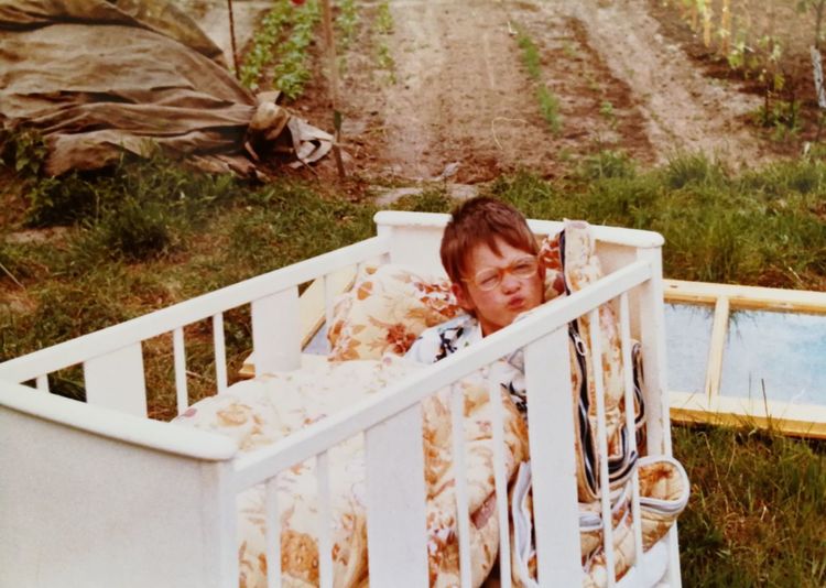 Portrait of boy lying in crib outdoors