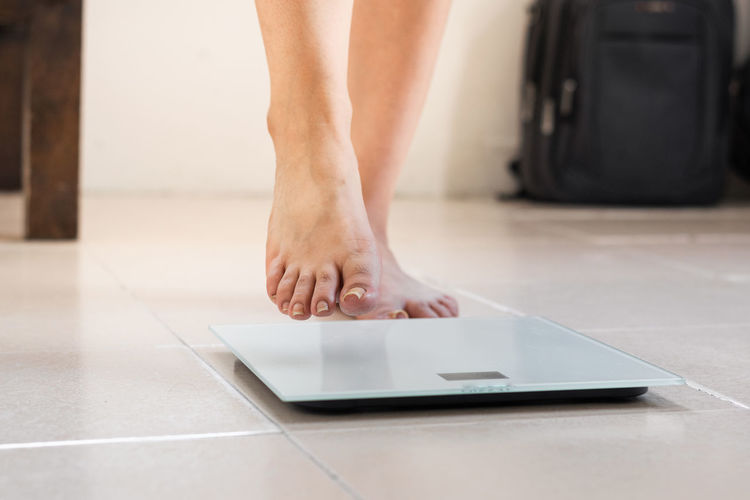 The feet of a latina woman, standing on a digital scale ready to calculate her weight