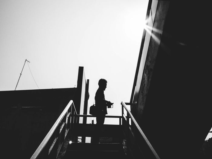 Low angle view of woman standing on railing