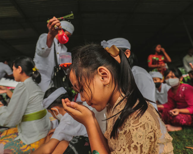 Hindus sipping holy water during celebrations before nyepi