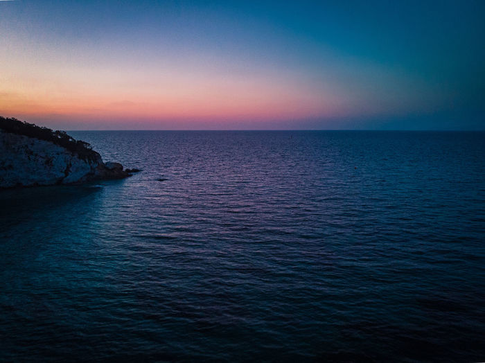 Scenic view of sea against sky at dusk