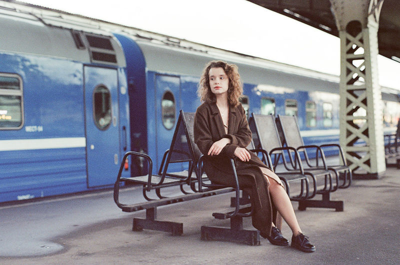 Full length of woman sitting at train