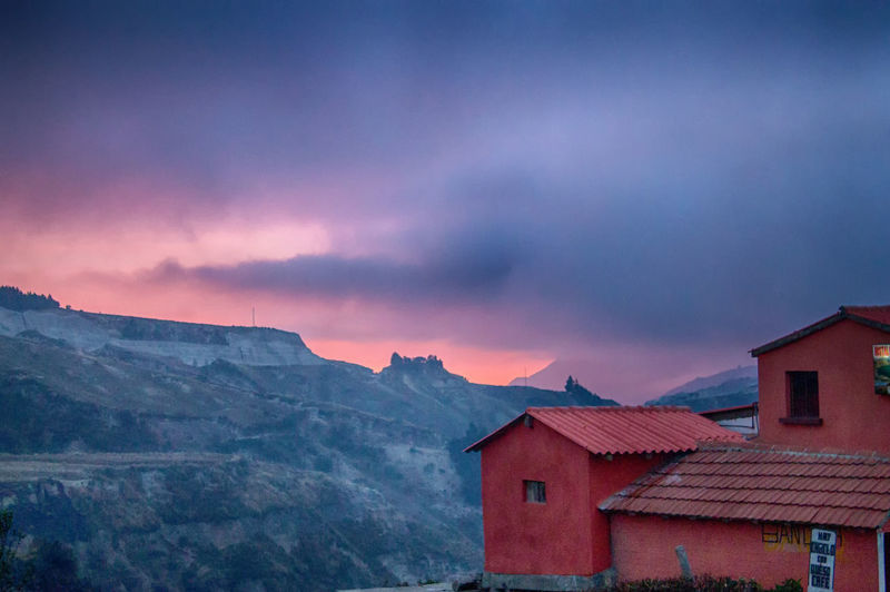 Exterior of houses against mountain during sunset