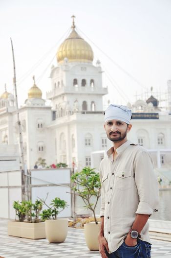 Portrait of man standing against golden temple