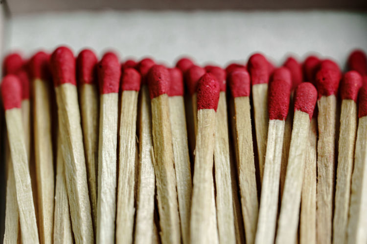Close-up of many red face matches in the box on a white background