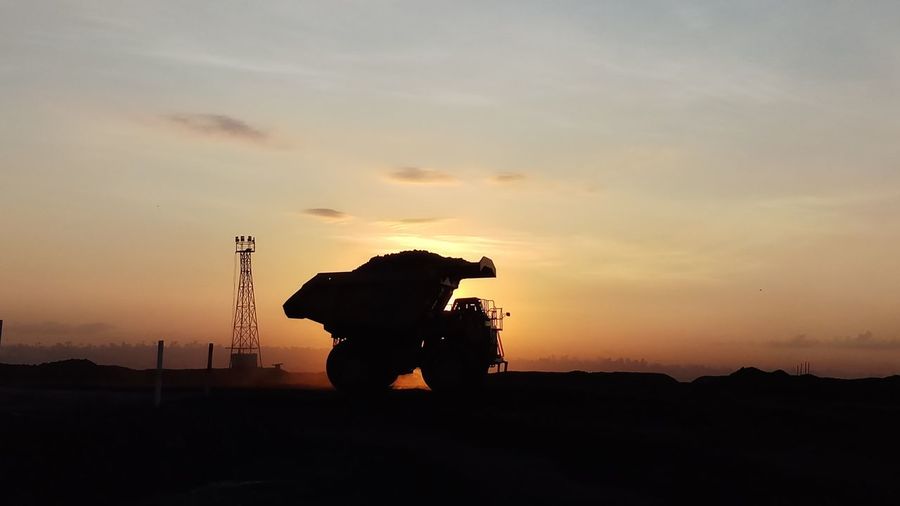 Silhouette heavy equipment  bring coal during sunset