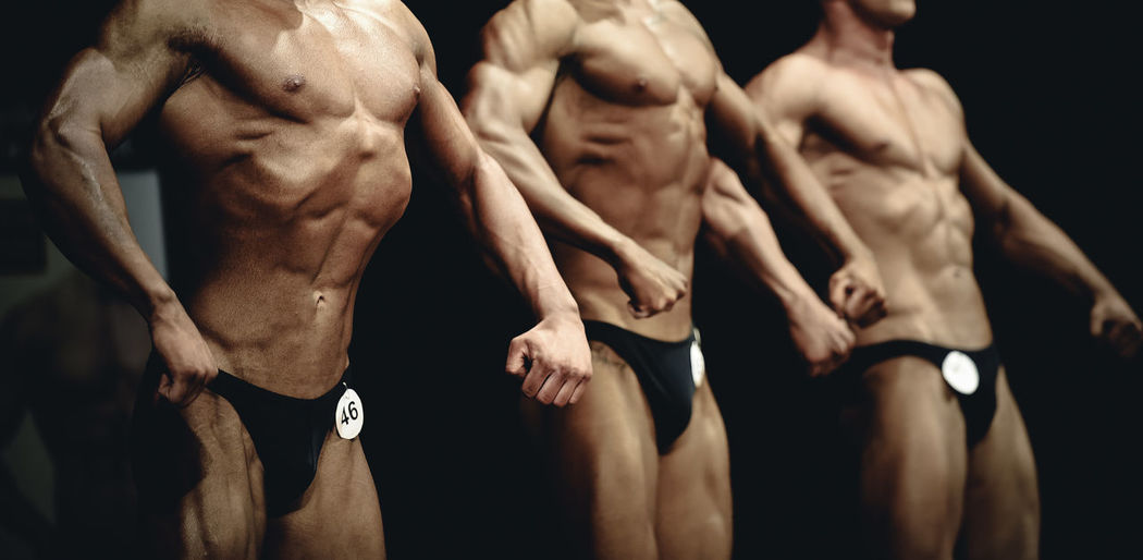 Body builders flexing muscles while posing on stage
