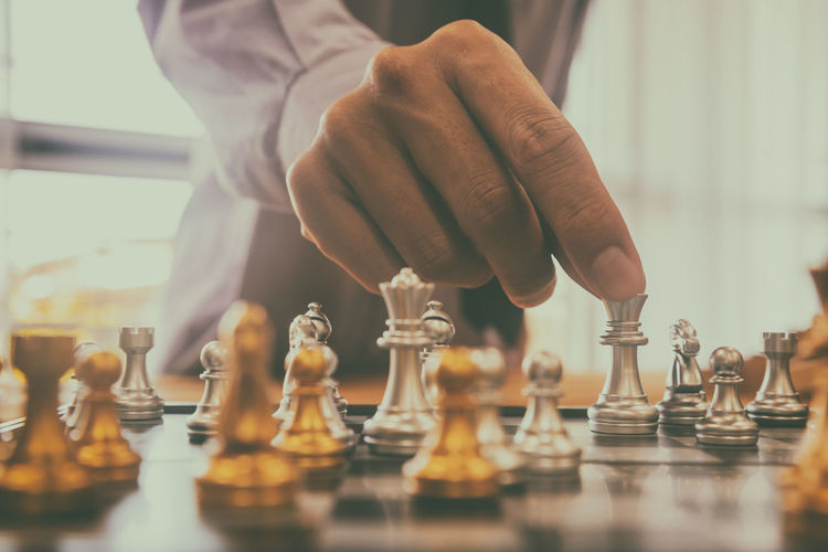 Midsection of man playing chess at home