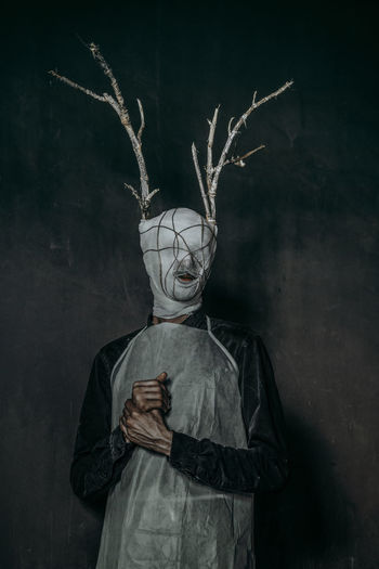 Portrait of person wearing mask standing at night