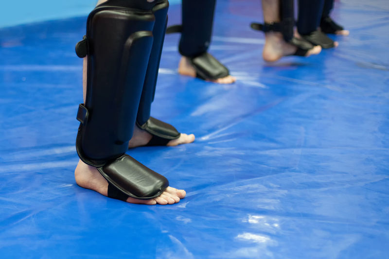 Low section of kickboxers standing on mat