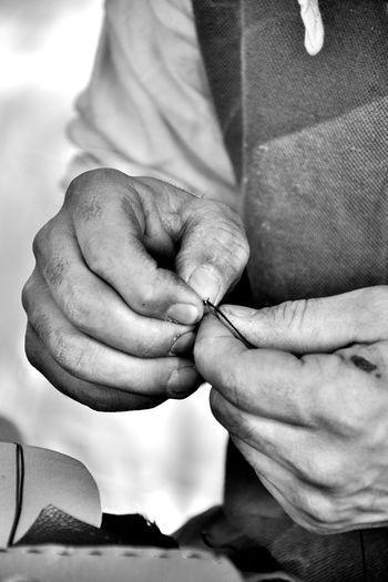 Midsection of tailor threading needle