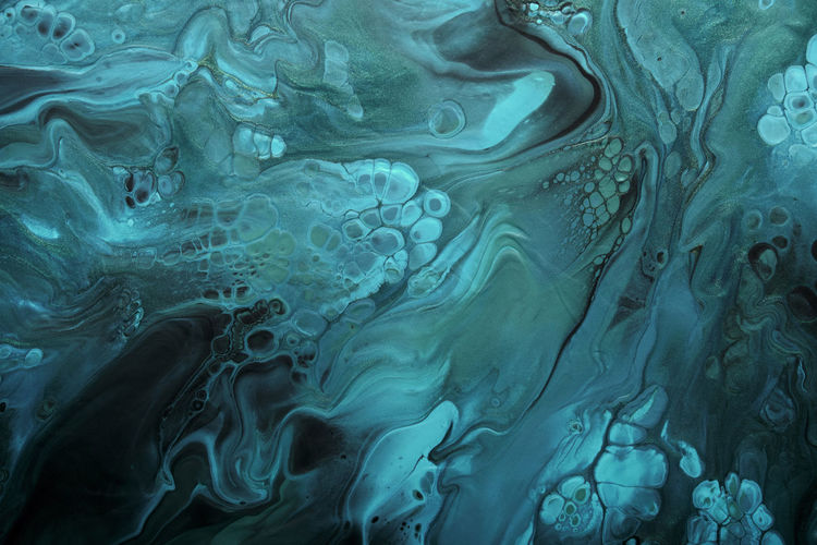 Fluid art. metallic green and blue abstract waves with golden particles on black background. marble
