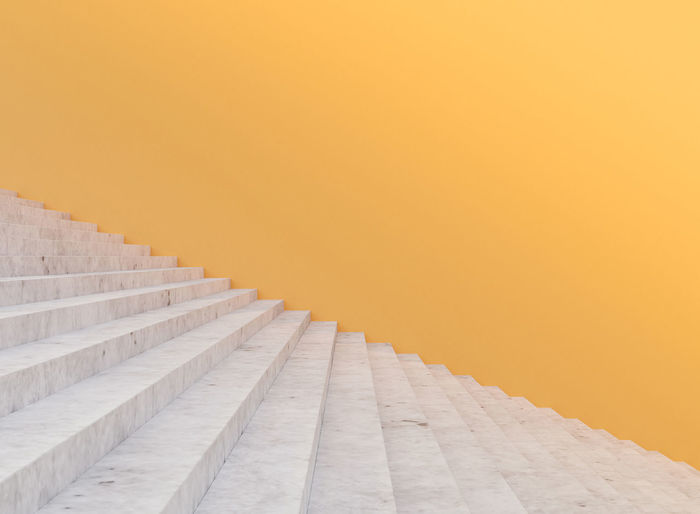 Minimal concrete staircase and yellow wall , 3d rendering
