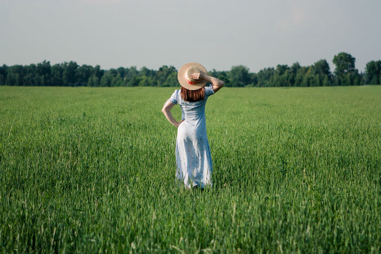 Woman in sunhat in green field
