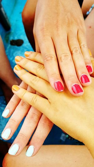 Cropped image of friends showing nail polish