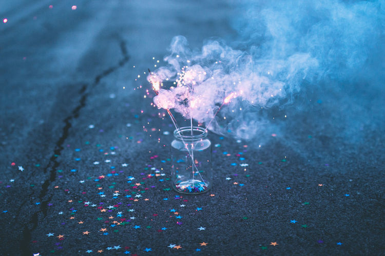 Close-up of burning sparklers in jar on road