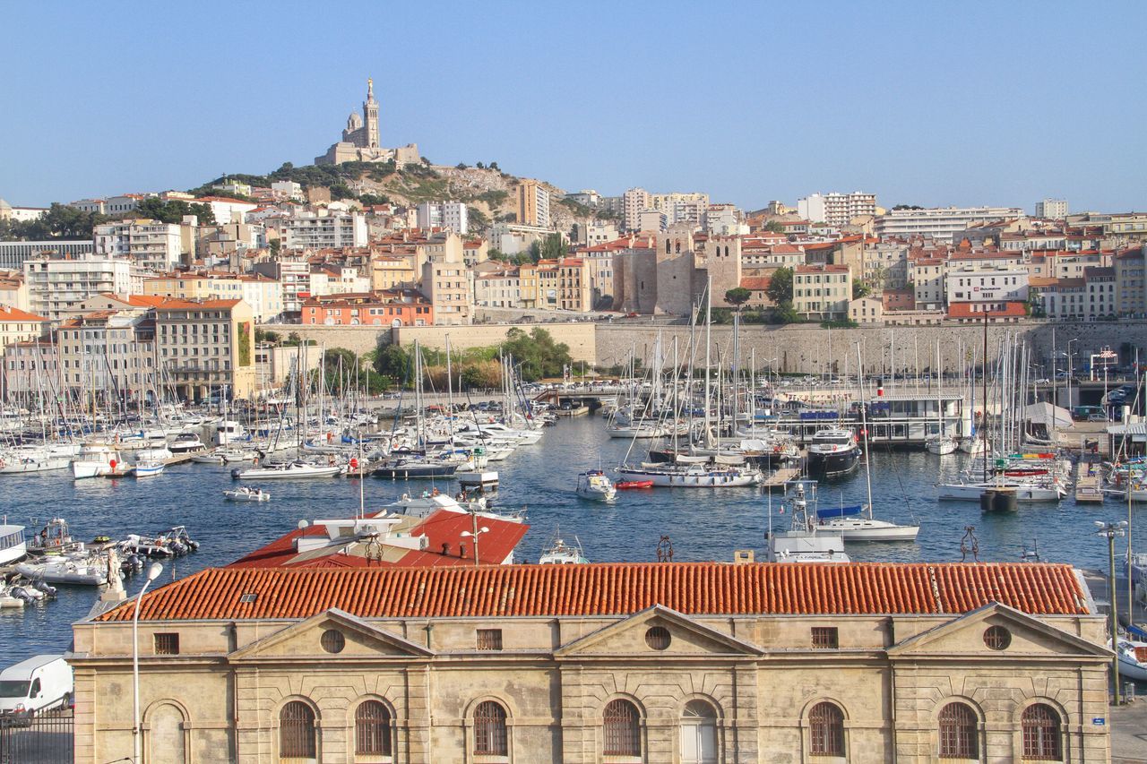 Sailing boats at harbor and church notre-dame de la garde in background