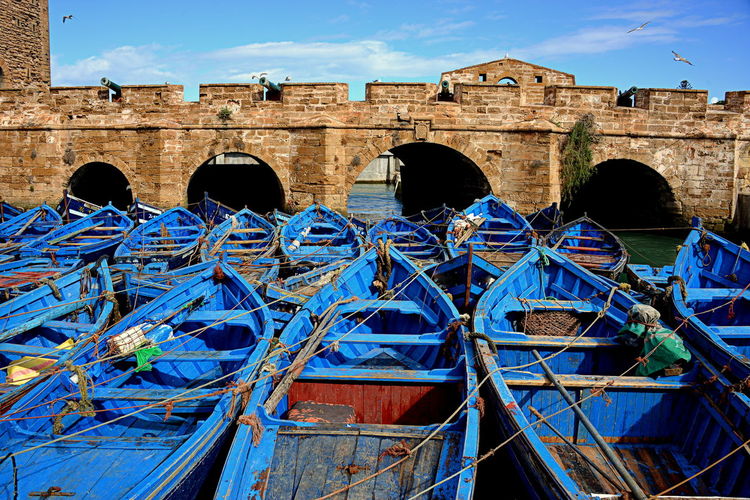 Boats moored against bridge