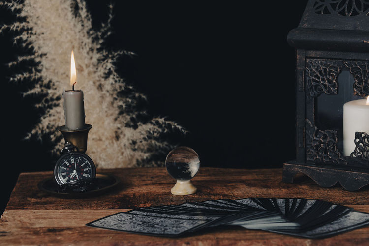 Dark wallpaper romantic scene of books, candles and mystery. night of tarot card pulling.