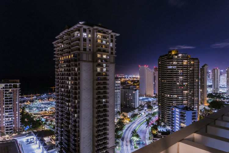 Illuminated buildings in city against sky at night