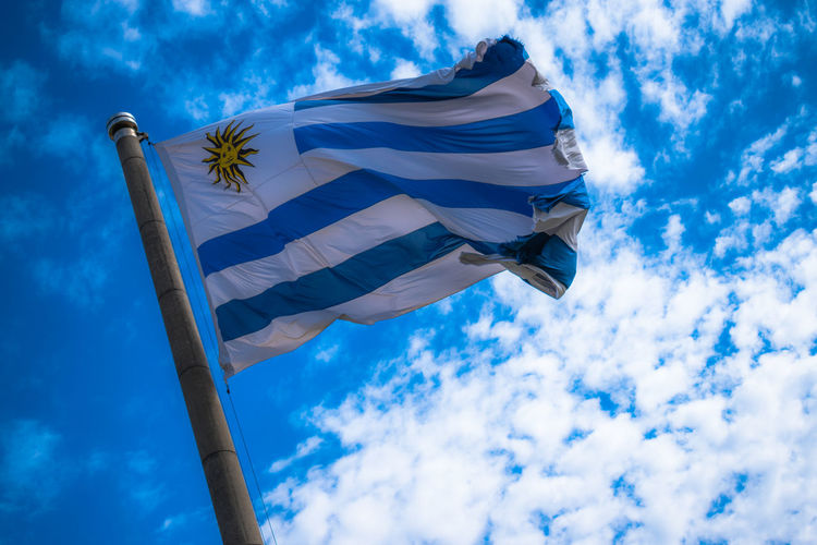Low angle view of uruguaian flag against cloudy sky