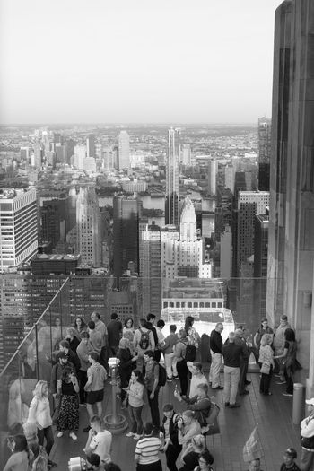 Group of people in city buildings against sky