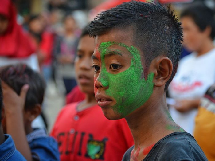 Close-up of boy with green face paint during celebration