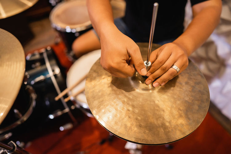 Cropped hand of musician adjusting cymbals