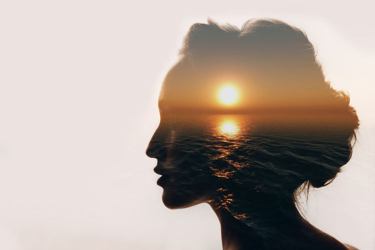 Digital composite image of woman and sea against sky during sunset