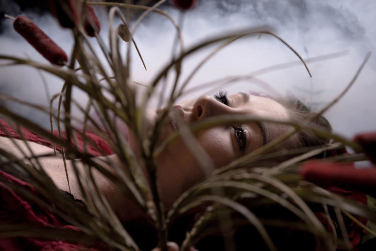 Close-up of woman lying by grass