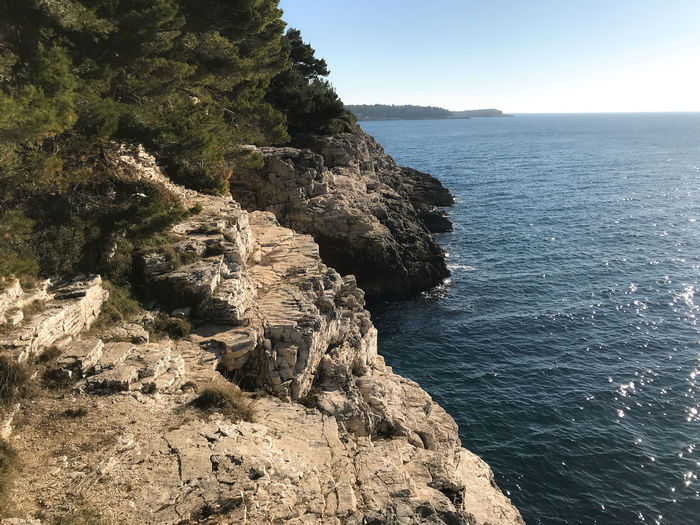 Rock formation in sea against sky
