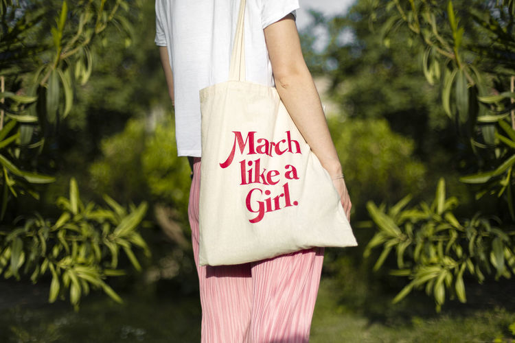 Midsection of woman holding a tote bag claiming womens day