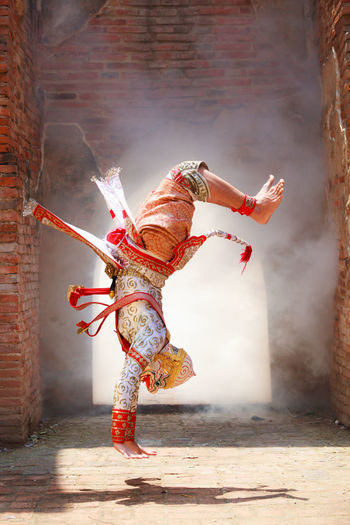 Male dancer wearing traditional clothing while performing on stage