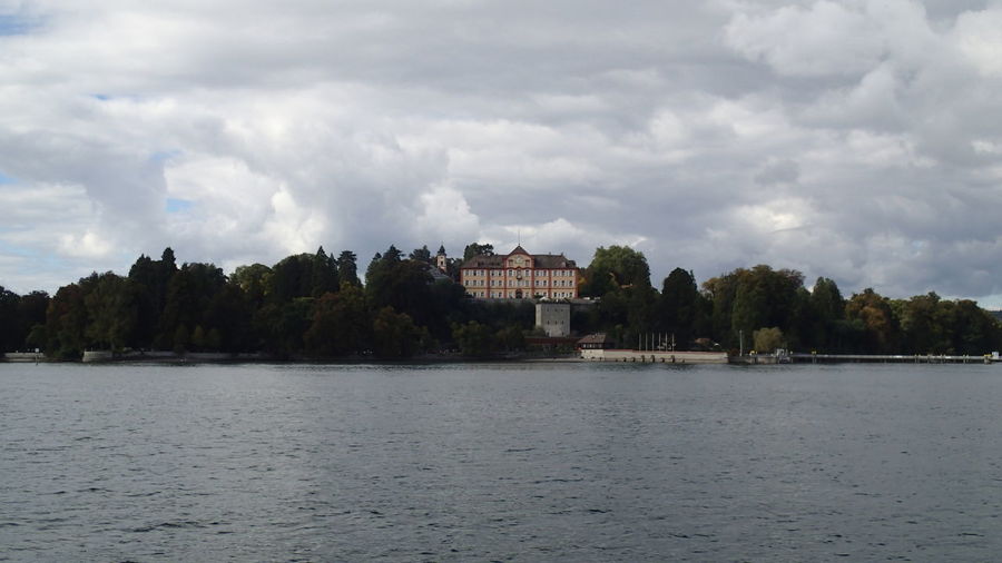 Scenic view of river by buildings against sky