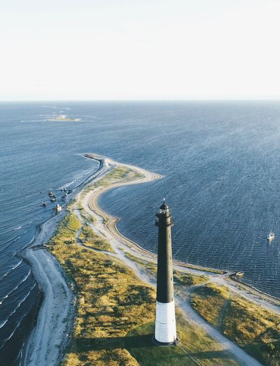 High angle view of lighthouse by sea against clear sky